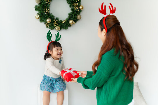 mother gives her daughter a big box with a gift.