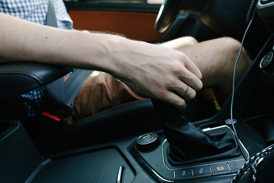 Man's hand grabbing the gear lever in the car