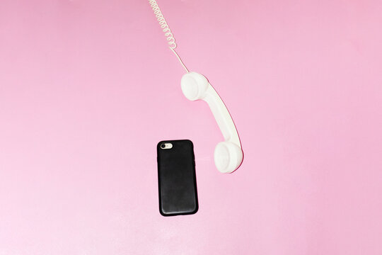 Old landline phone and modern smartphone on a desk with flashlight