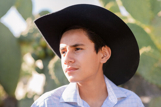 Teen Cowboy by Cactus Trees