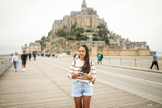 woman with mobile phone on mont saint michel in france