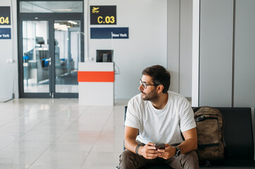 Handsome Man Sitting at Airport and Waiting for Flight