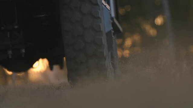 Wheel of a war machine. Slow motion close-up shot of moving military vehicles. Armored personnel carrier. Wheel of a military vehicle moves forward on the ground towards the camera, bottom view.