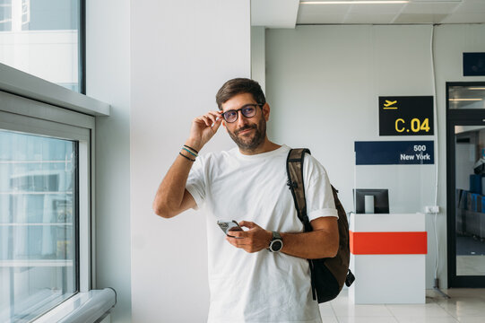 Portrait of Young Handsome Man With Mobile Phone at Airport 