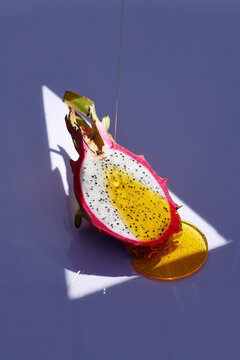 Delicious fresh dragon fruit with dripping honey on a color background