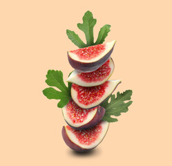 Stacked fresh figs and green leaves on beige background