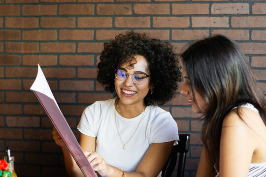 Two young friends ordering food in a restaurant.