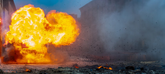 explosion on the street with fiery clouds. horizontal banner with real explosions and flames on a...