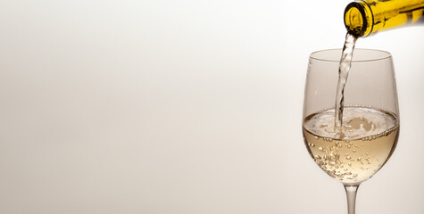 white wine is poured into a glass horizontal banner for a postcard with free space for text