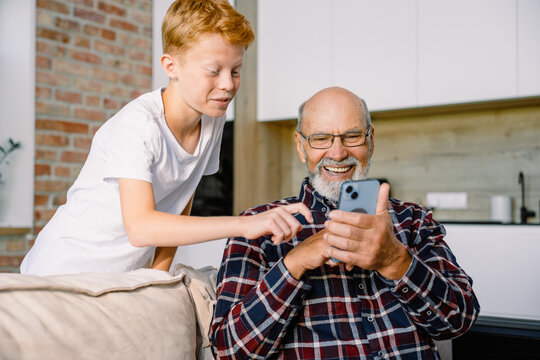 Grandfather and grandson use mobile at home