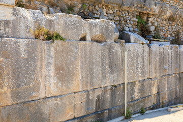 Antique wall made of huge blocks with minimal gaps. Background with selective focus and copy space