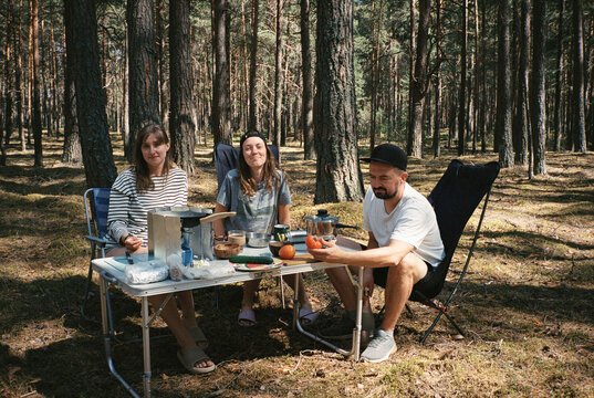 Young friends at camp table in a forest 