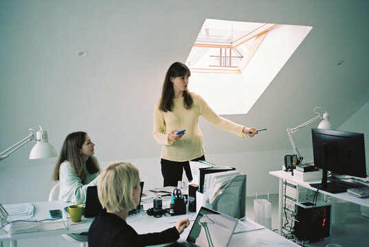 Three young women discussing smth in the office