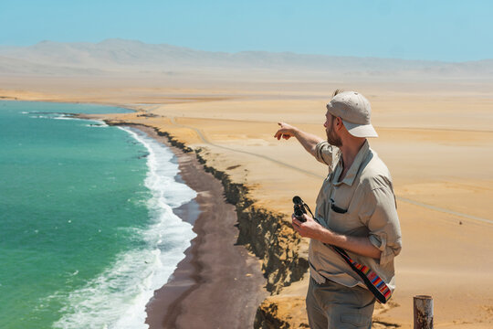  Tourist with binoculars in a shoreline