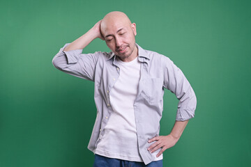 Fototapeta premium Funny Man Forget and Doing Mistakes, Feel Wrong, Standing Isolated on Green Background. 