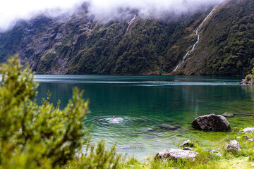 pretty girl in a swimsuit swim in famous alpine lake marian surrounded with mountains lake in...