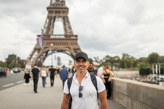 Tourist man walking in Paris with backpack
