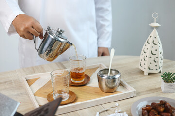 Close Up Hand Pouring Hot Tea For Breakfasting on Iftar Ramadan 