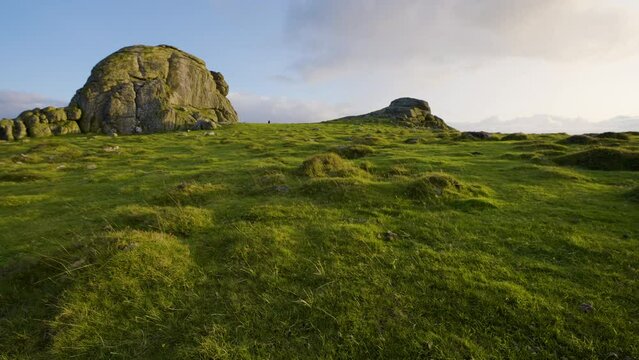 Panning shot over green hills with low angled evening light