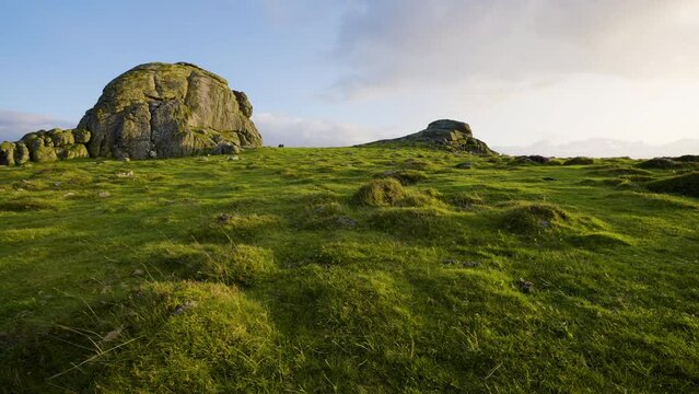  Low angle light shines across green hills on Dartmoor National Park
