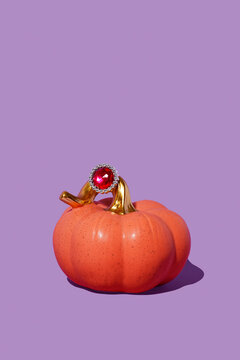 pumpkin wearing a ring with a red gemstone