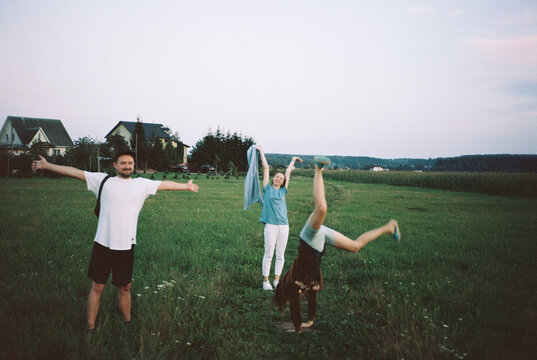 Three happy friends having fun in the field in summer