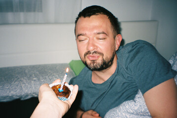 Sleepy man blowing out the candle in the early morning