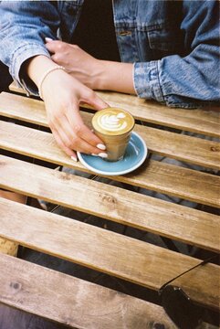 Anonymous woman holding a glass with coffee