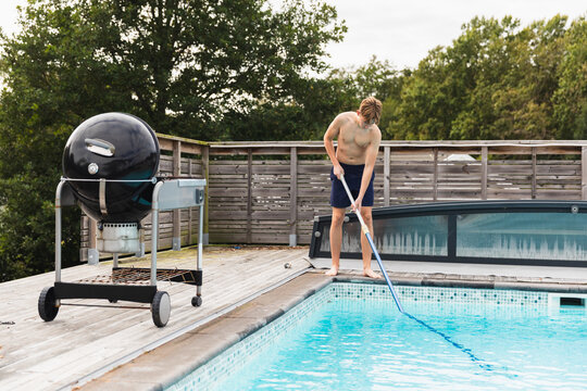Teen cleaning pool with net