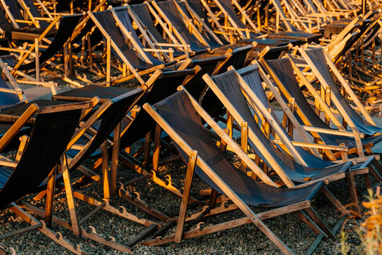 Rows of sun loungers in the early sunny morning near a closed cafe