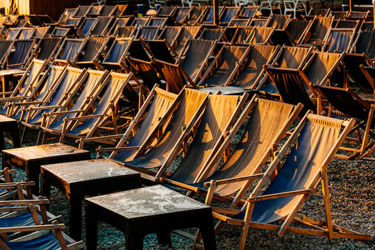 Lots of rows with empty deck chairs in the early morning outdoors
