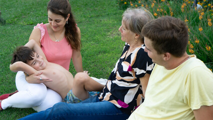 mom with her son in her garden while they share a moment in the garden with grandmother and uncle