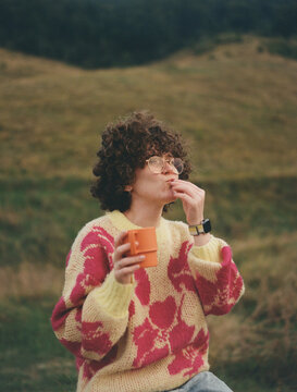 a young woman with a Tupperware cup in the mountain