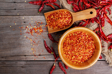 Dried chilies with chili powder, pepper, and red paprika in a wooden bowl Spicy seasoning Healthy...