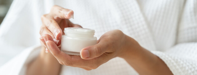 Fototapeta na wymiar Close-up woman using skin care serum cream in daily routine.