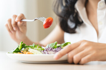 Diet, Dieting asian young woman or girl use fork at broccoli on mix vegetables, green salad bowl, eat food is low fat good health. Nutritionist female, Weight loss for healthy person. - obrazy, fototapety, plakaty