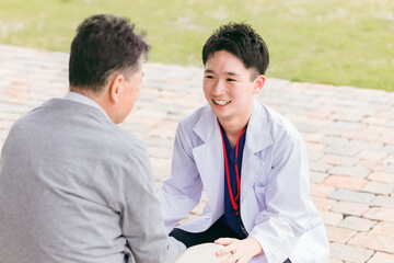 患者とコミュニケーションを取る若いアジア人医師・医者
