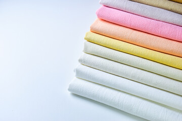 stack of colourful cotton clothes, pile of clothing on white background