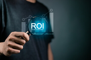 ROI, Return on Investment concept. Investment of some resource yielding a benefit. investment business. Person use magnifying glass focus to ROI icon on virtual screen.