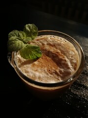 Сup of coffee tea on the black table with a homemade cake decorated with a fresh mint brown sun light morning breakfast drink food baked bakery