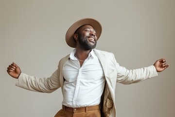 Joyful African American man in a stylish hat and outfit expressing happiness, concept of success and positivity
