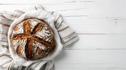 Loaf of a sourdough rye bread on a linen towel. Seen from above. Homemade bread. Healthy food. White wooden background. Top view. Copy space. - obrazy, fototapety, plakaty