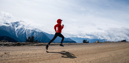 Woman trail runner cross country running at high altitude mountains