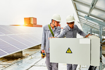 Two Asian workers are inspecting solar photovoltaic cells