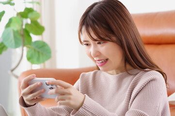 真剣な表情でスマートフォンを見つめる女性