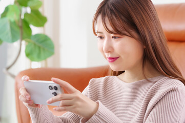真剣な表情でスマートフォンを見つめる女性