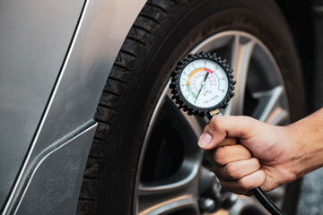 Hand car mechanic holding car tire pressure check equipment tool to checking low tire pressure inflating tires to or refill or air inflate to safety and car care service maintenance inspection.