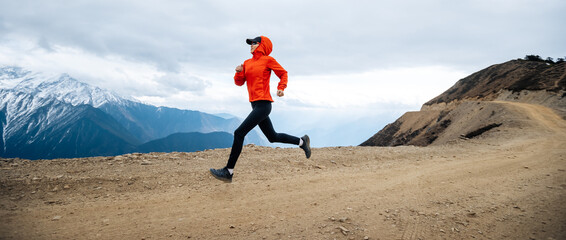 Woman trail runner cross country running at high altitude mountains