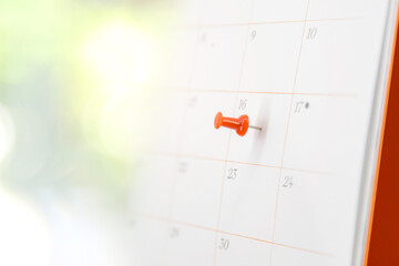 Red pin on blank desk calendar in office workplace concept time management event planner or personal organization for business meeting and appointment reminder and schedule planning or holiday plan.