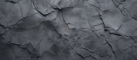 Close-up of cracked cement surface, providing a dark grey textured wallpaper.